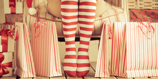 Holiday theme with gifts and lower legs wearing red striped stockings
