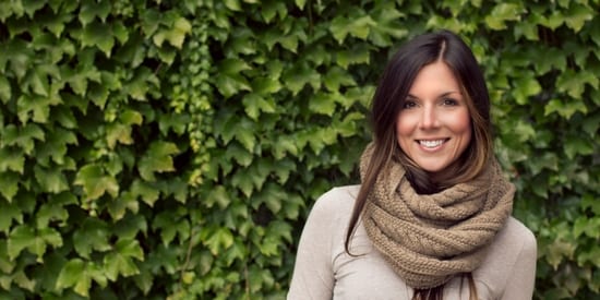 Smiling, attractive woman wearing sweater and scarf around her neck