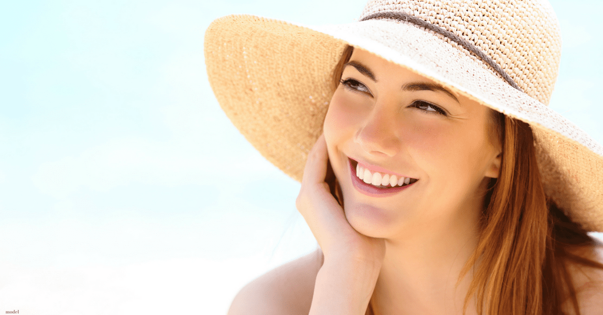 Young woman smiling in sun hat