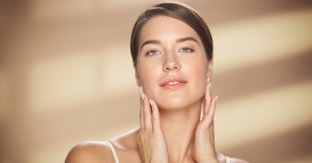 a woman with their hands on their face (model)