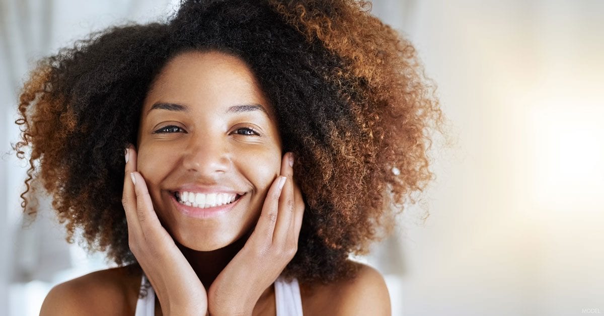 A woman smiles with joy (model)