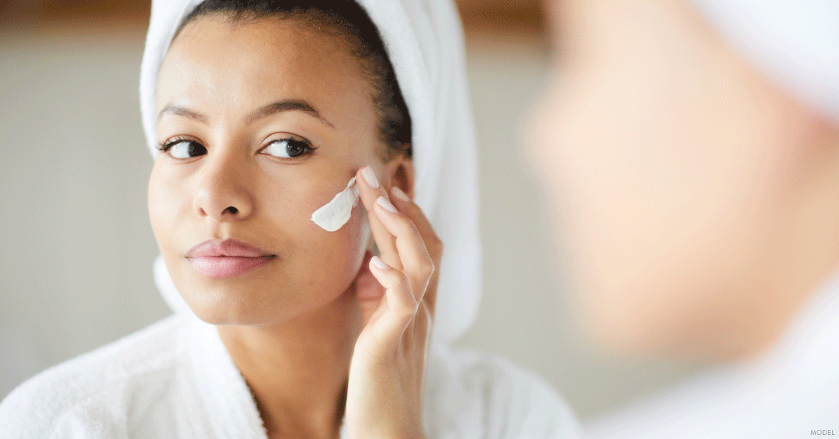 Woman in Dallas, TX applying skincare product recommended by her dermatologist