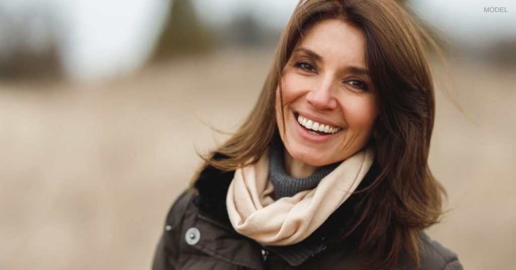 Woman with clear and beautiful skin (model) smiling outdoors in fall.