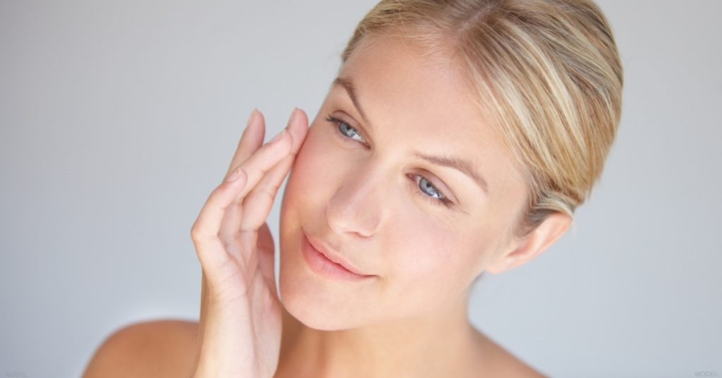 Woman touching her face with her hand (model)